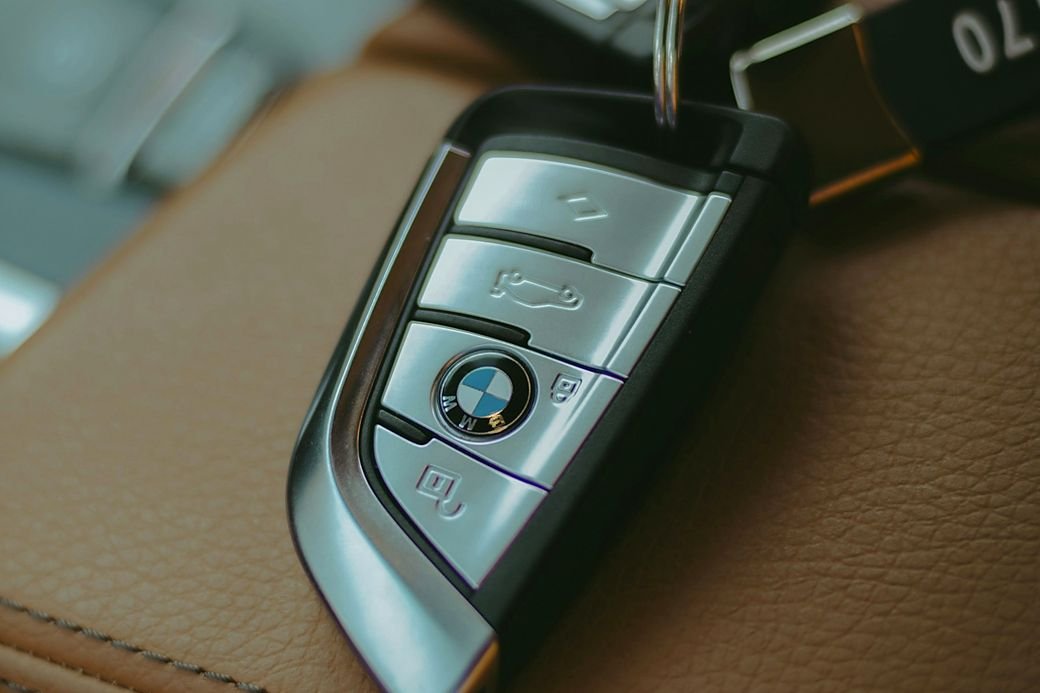 A BMW key fob resting on a leather car seat