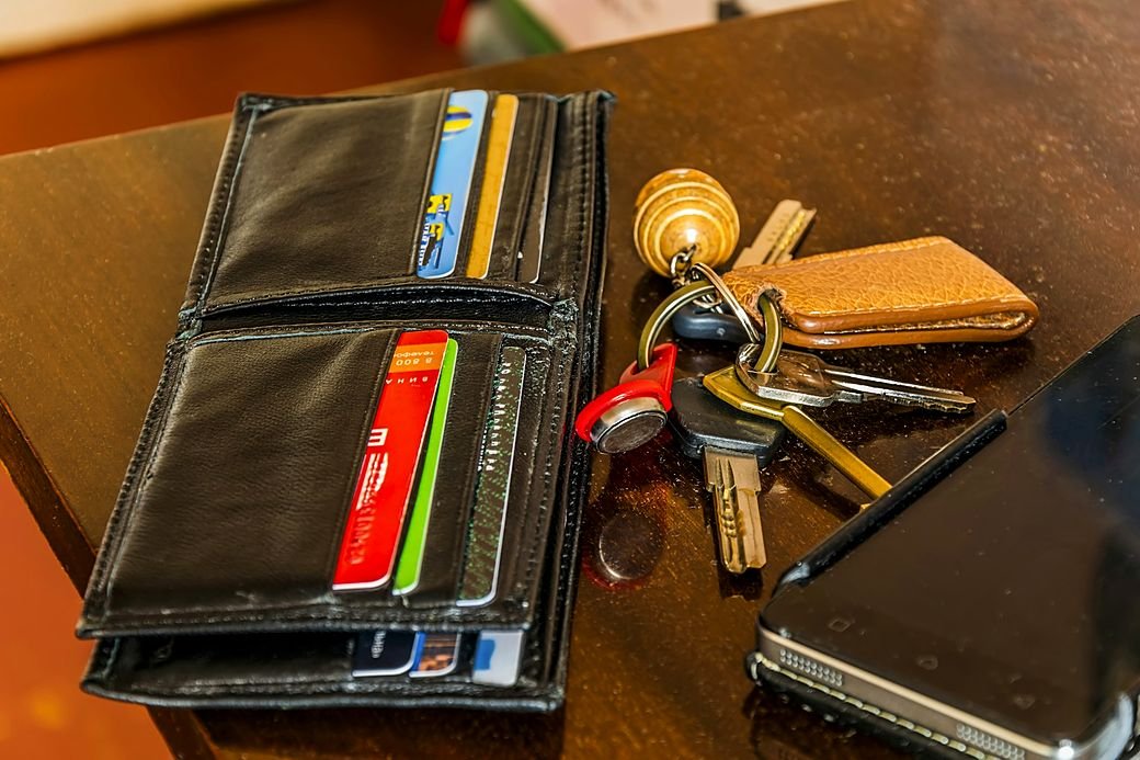 A set of keys beside a wallet on a table